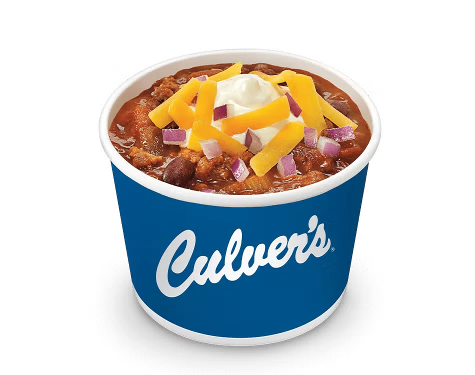 Culver’s George’s Chili Supreme topped with shredded cheese, sour cream, and chopped onions in a hot, hearty bowl